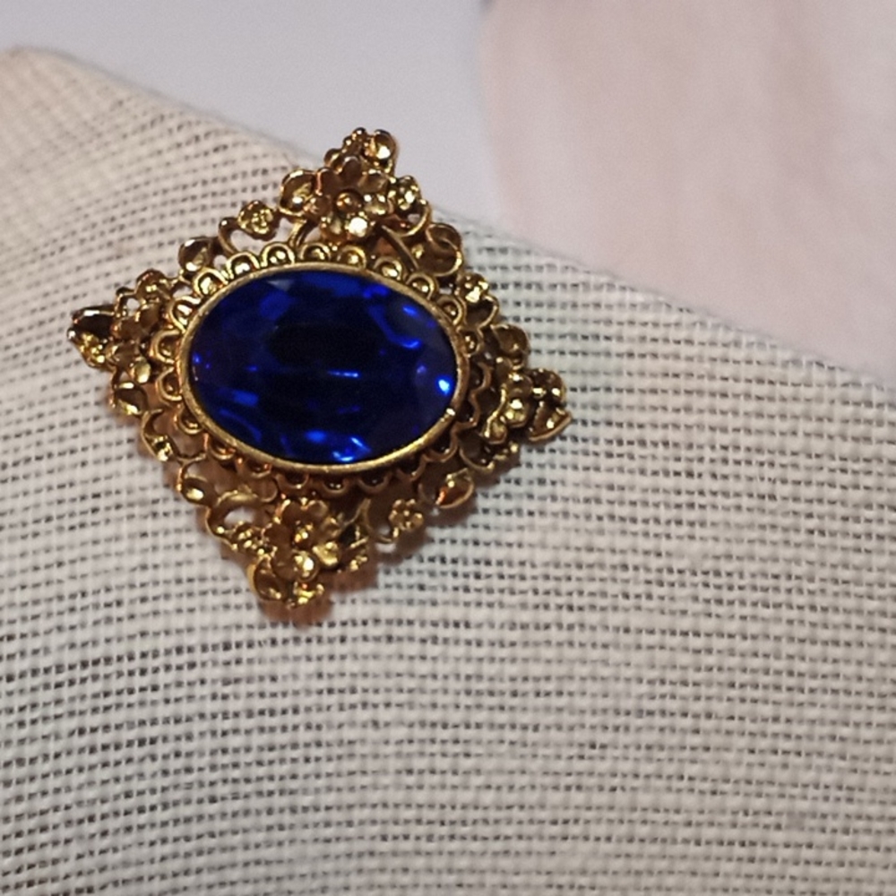 Vintage brooch. Gold toned. Blue rhinestone.